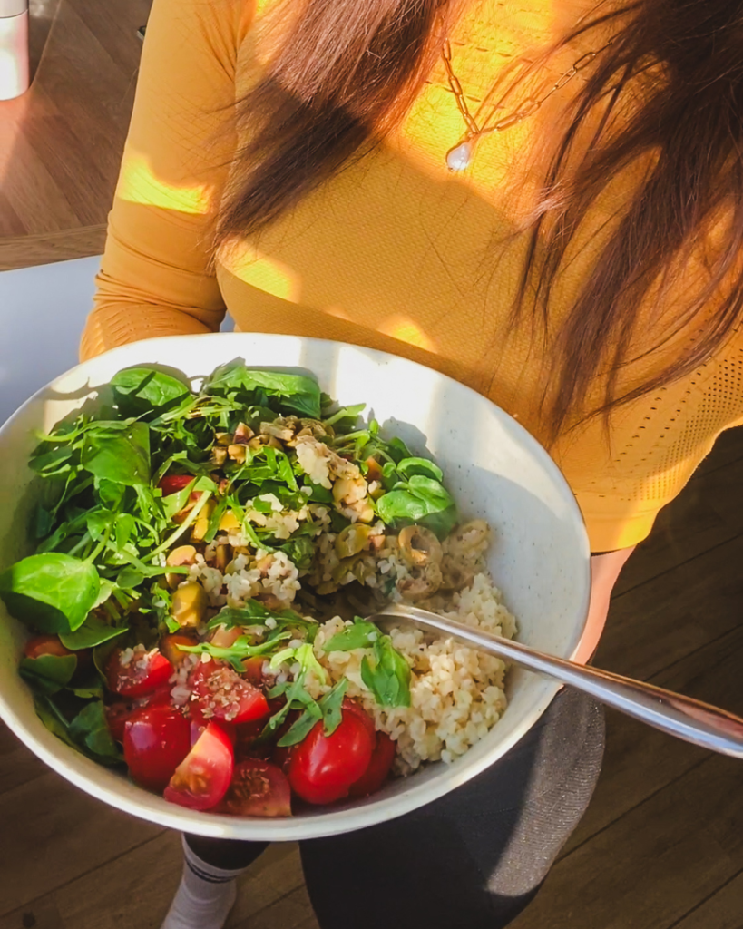 Plant based bowl of nourishing plant foods - girl holding a bowl of fresh grains and veggies